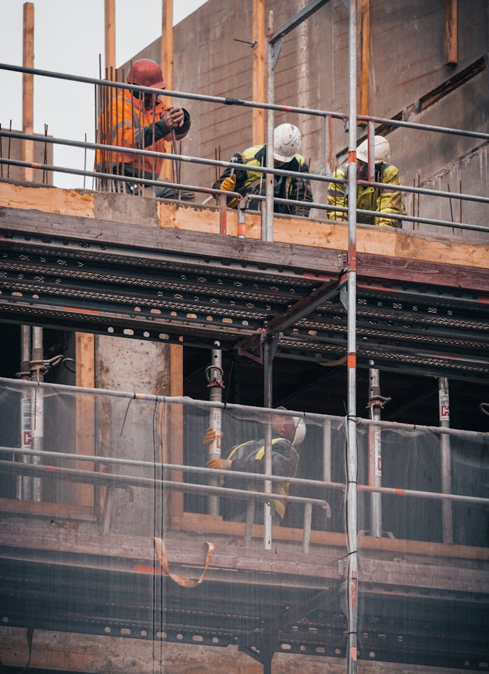 ours-journey Construction workers engage in building tasks on a scaffold in Hamburg.
