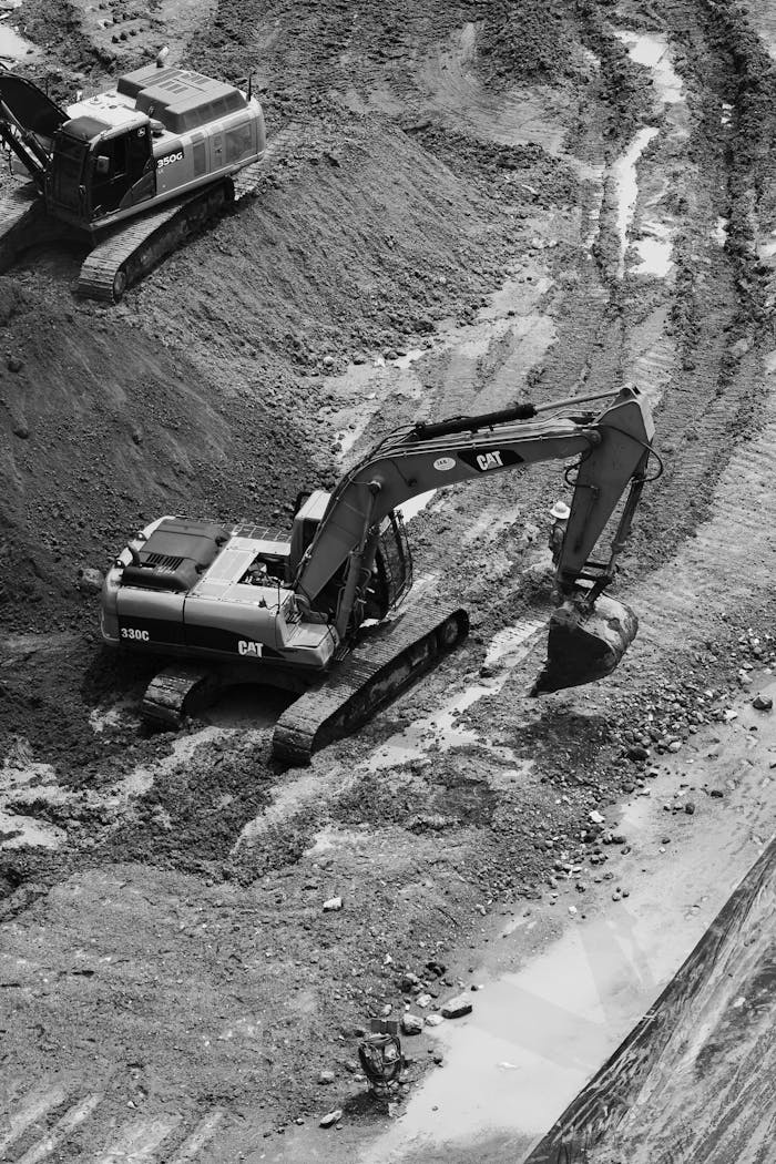 about-02 Black and white image of excavators working at a construction site in Ciudad de México, showcasing industrial activity.