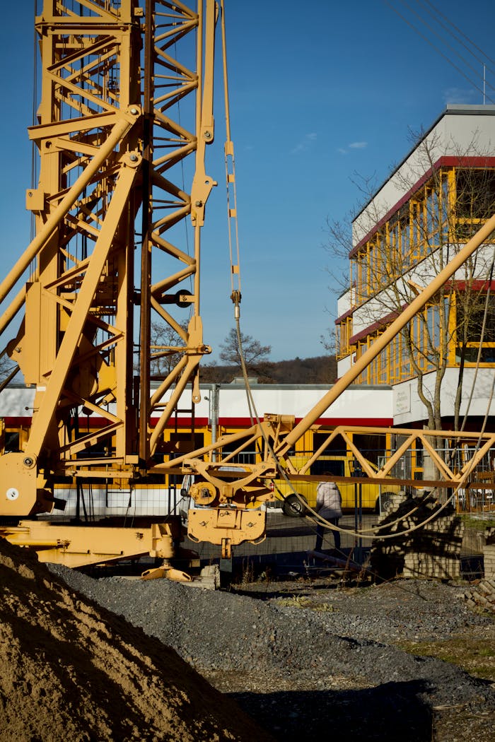 The Art of Drawing Readers In: Your attractive post title goes here A large construction crane at an urban worksite with clear blue skies, captured during the day.